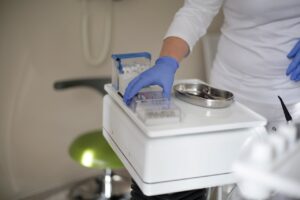 Dentist with gloves organizing dental tools in a clinic setting.